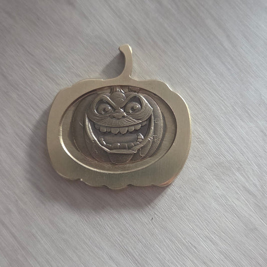 Decorative metal object with intricate design on a gray surface