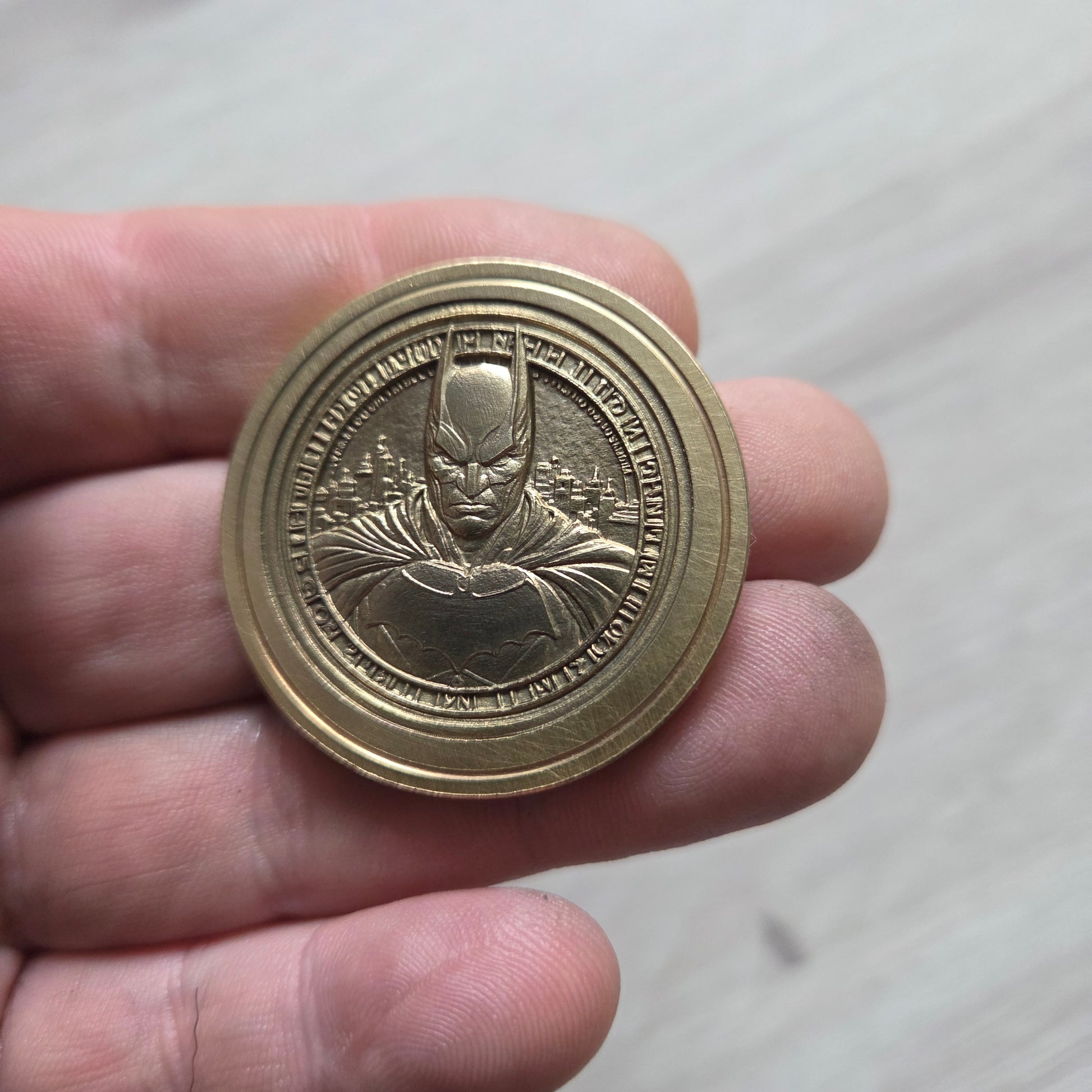 Gold coin held in a hand against a plain background