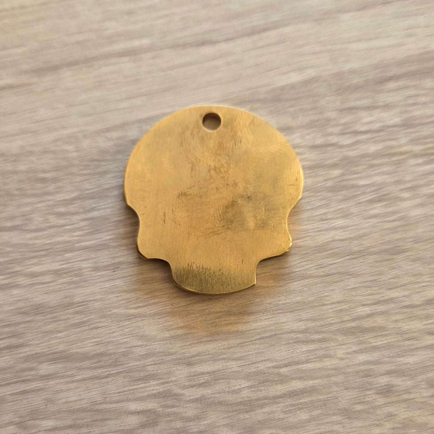 Gold dog tag on a wooden surface