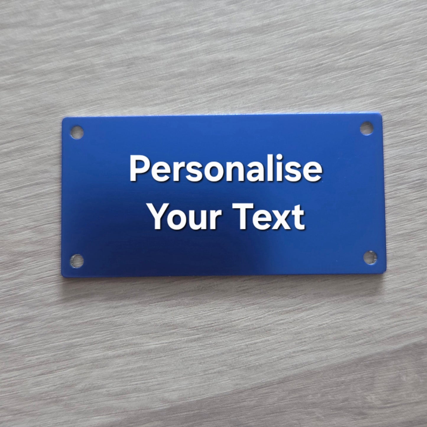 Blue sign with 'Personalise Your Text' on a gray wooden background