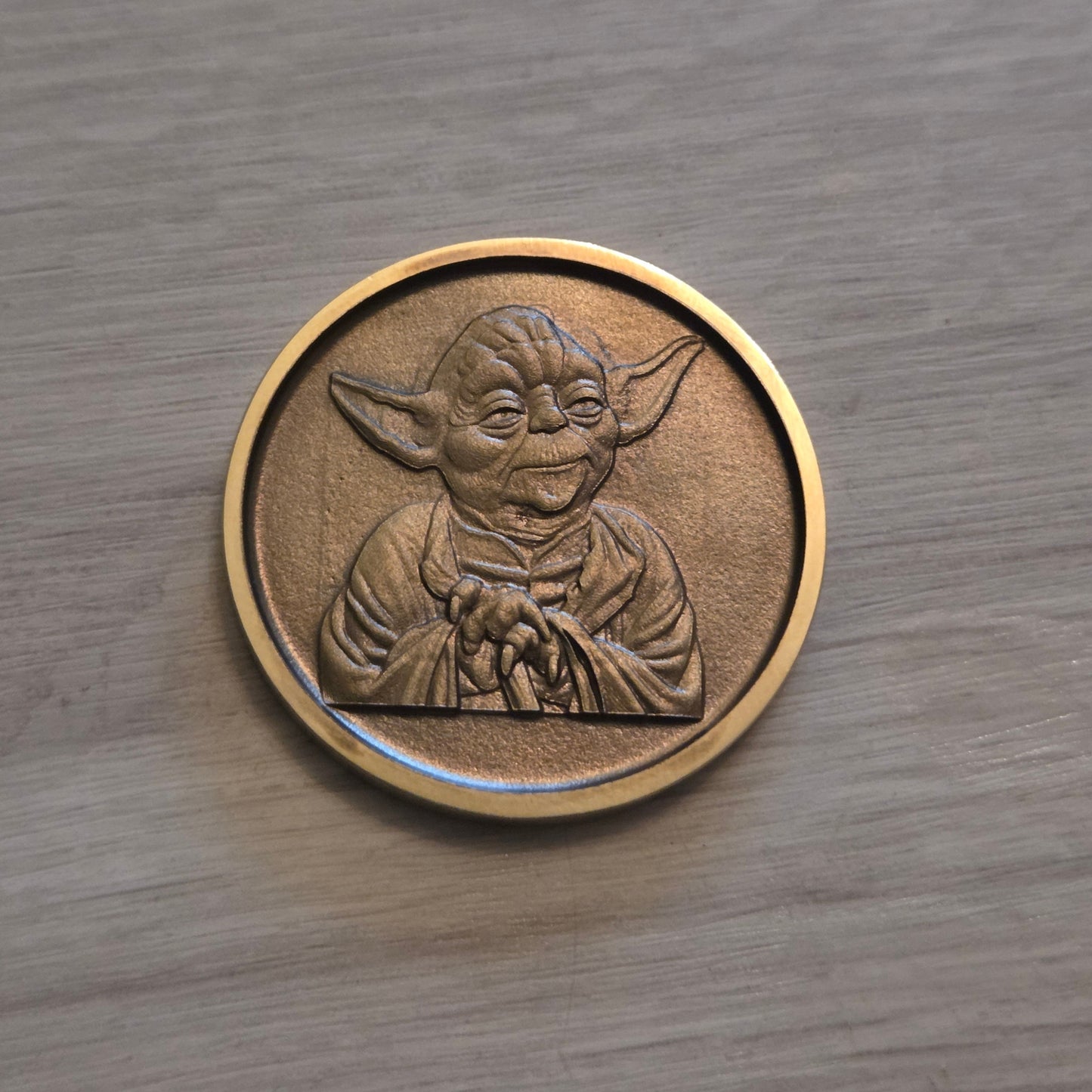 Bronze coin with a design on a wooden surface