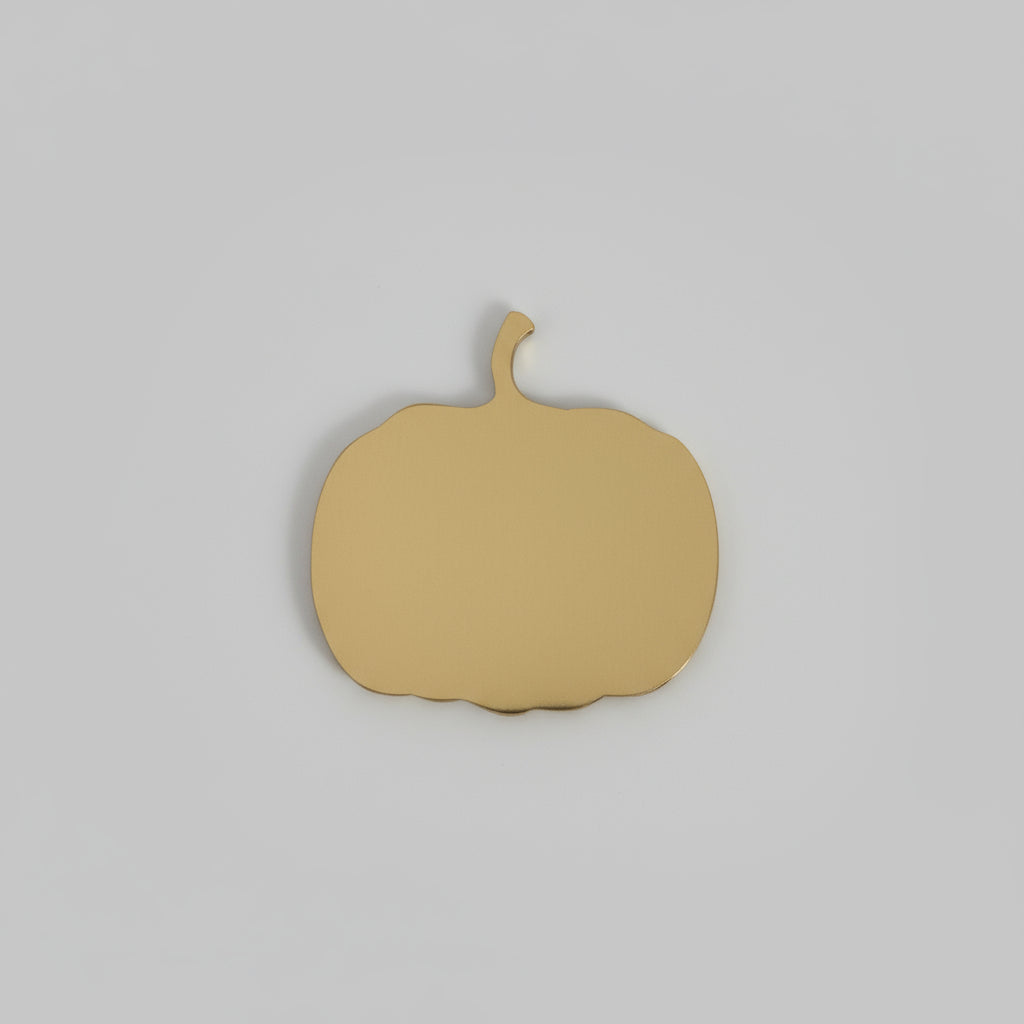 Bronze pumpkin-shaped object on a wooden surface