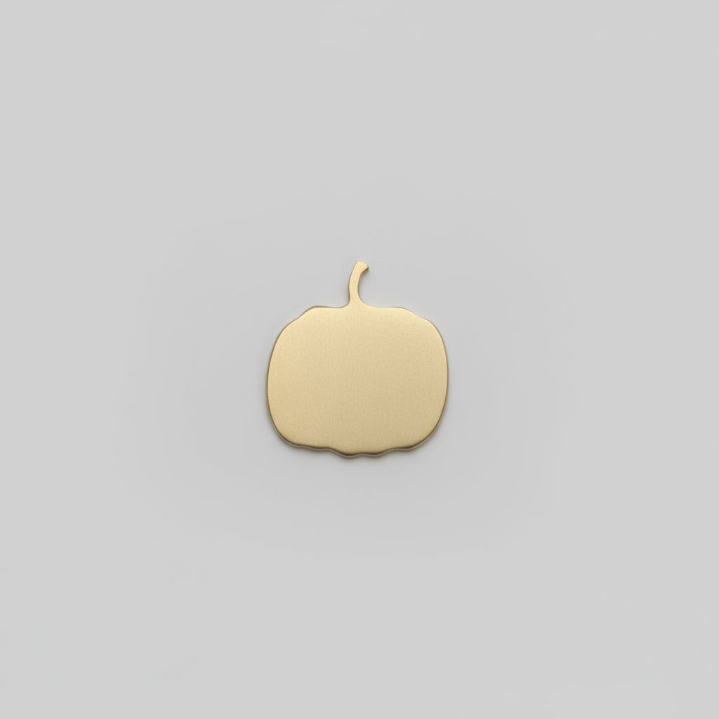 Gold circular object held in a hand against a wooden surface