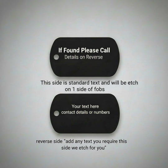 Two black dog tags on a light wood surface with text on each tag.