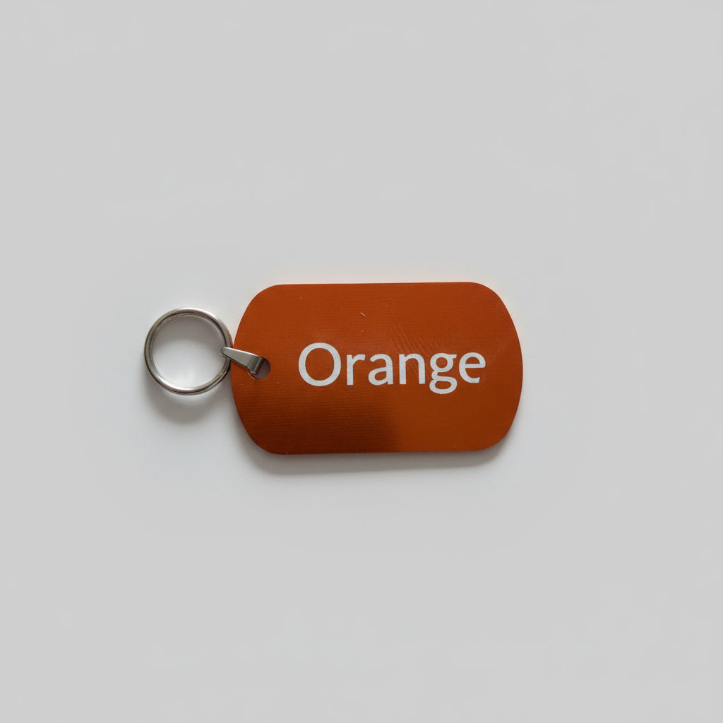 Orange key tag with 'Orange' text on a gray surface