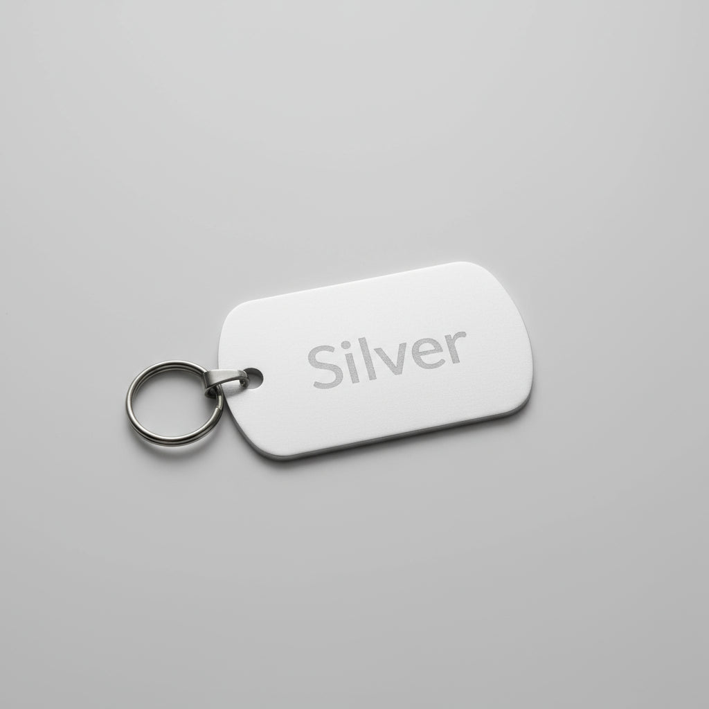 Metallic key tag with 'Silver' engraving on a wooden surface