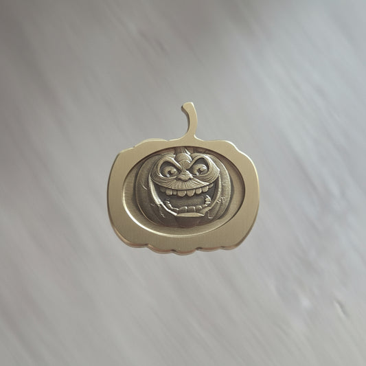 Hand holding a brass key with a decorative design against a neutral background