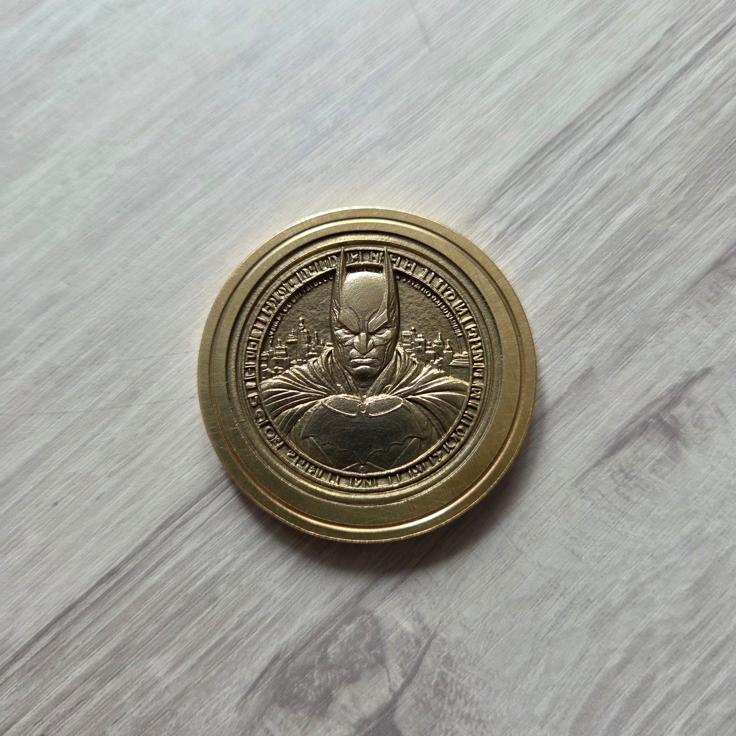 Bronze coin with embossed design on a light wooden surface
