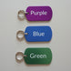 Three color tags labeled Purple, Blue, and Green on a wooden surface.