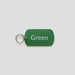 Green tag with 'Green' text and a key ring on a gray wooden surface