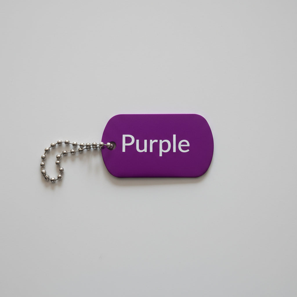 Purple keychain tag with 'Purple' text on a wooden surface