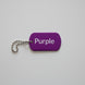 Purple keychain tag with 'Purple' text on a wooden surface
