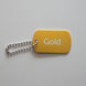Gold-colored keychain with a spring mechanism on a gray surface