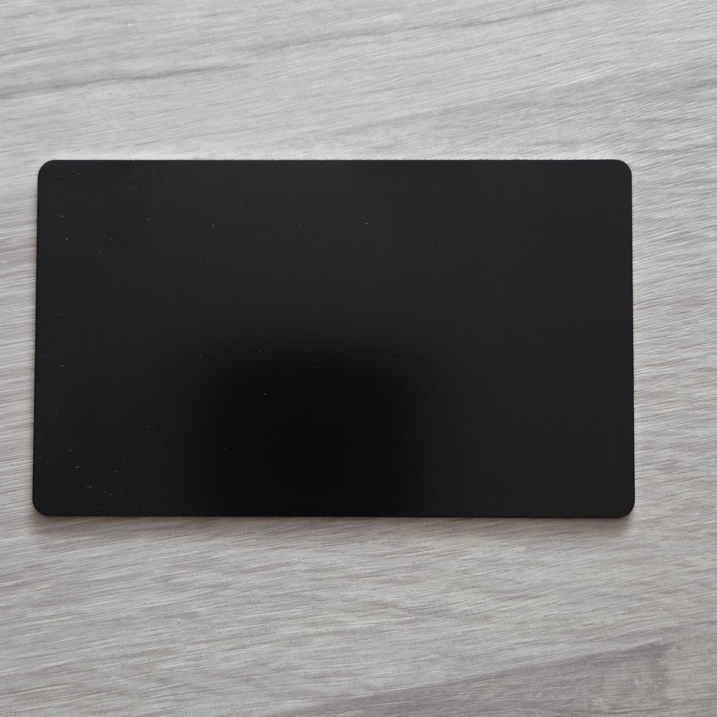 Black rectangular card on a light wooden surface
