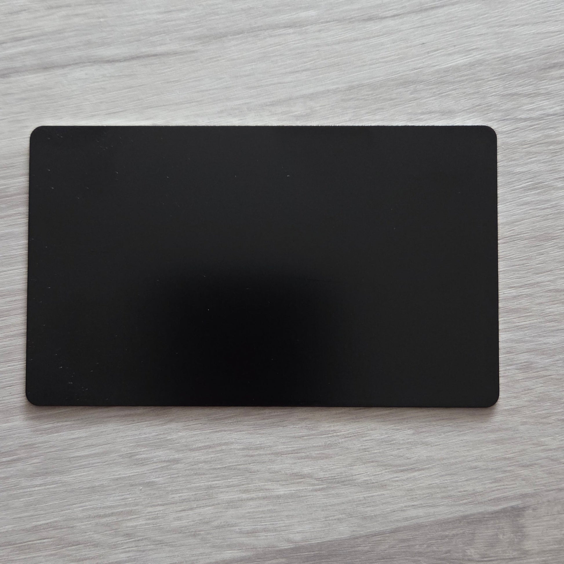 Black rectangular card on a light wooden surface