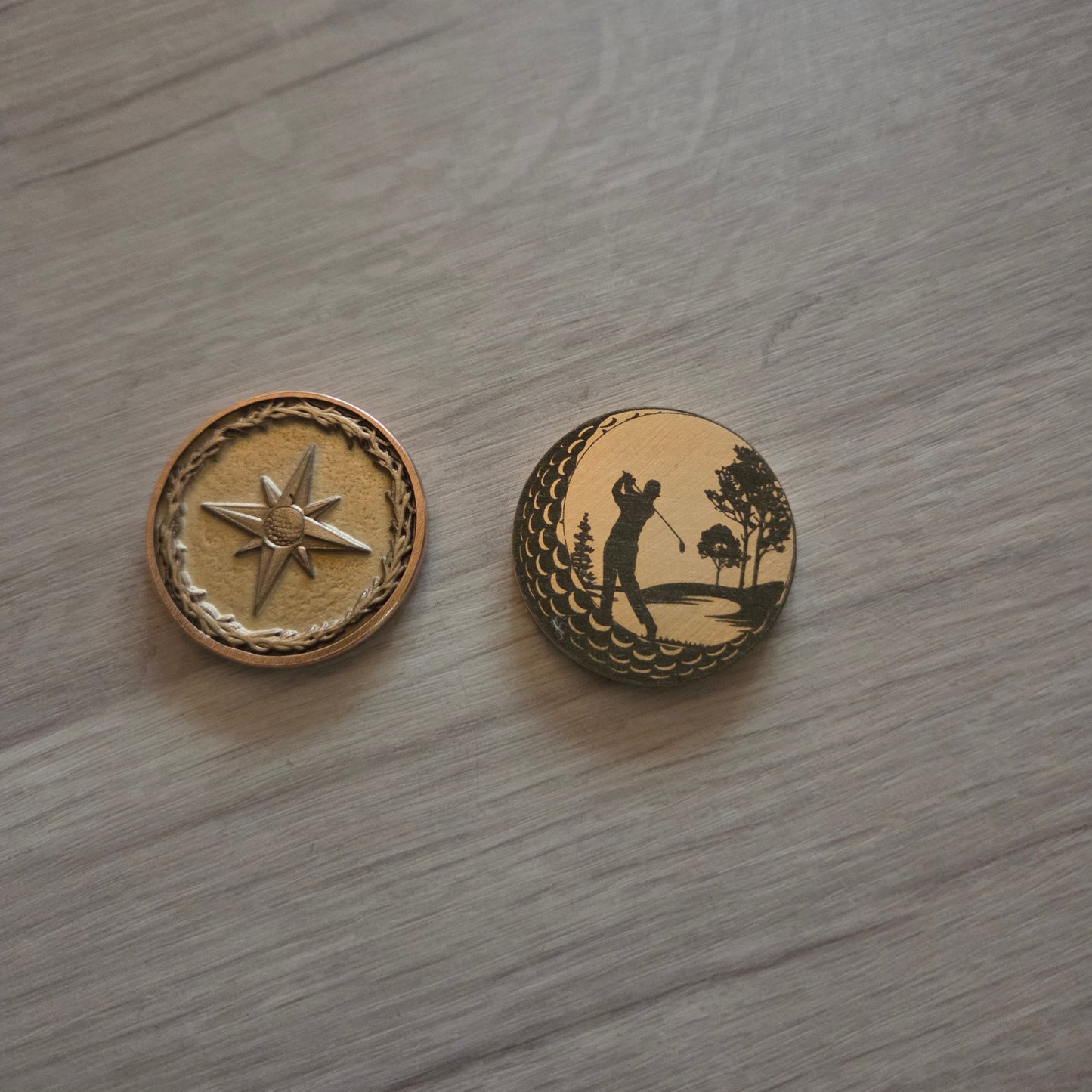 Two decorative buttons with star and anchor designs on a wooden surface