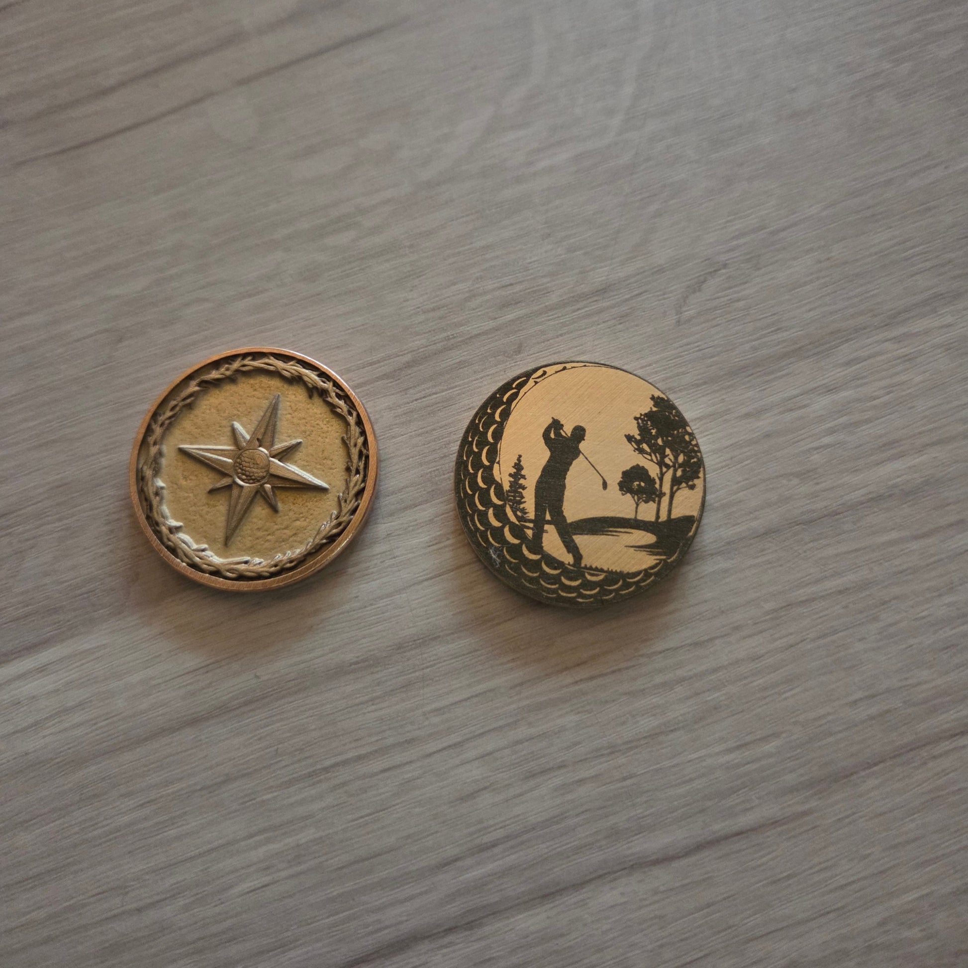 Two decorative buttons with star and anchor designs on a wooden surface