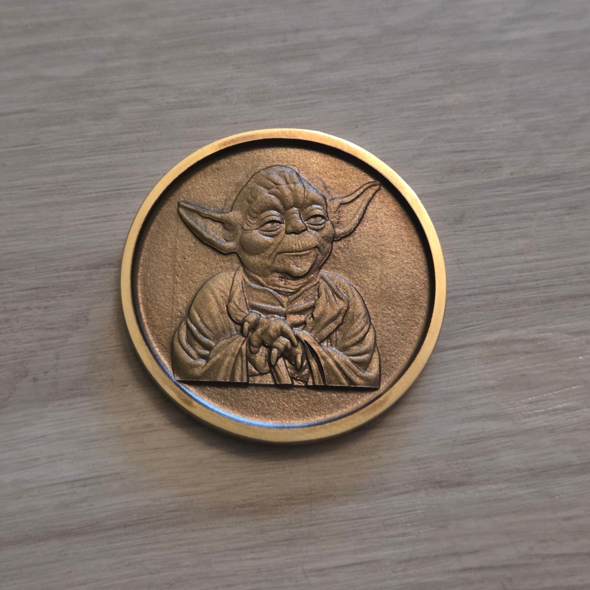 Bronze coin with a design on a wooden surface
