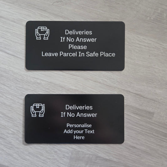 Two black plastic cards with text and icons on a gray wooden surface