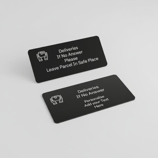 Two black plastic cards with text and icons on a gray wooden surface