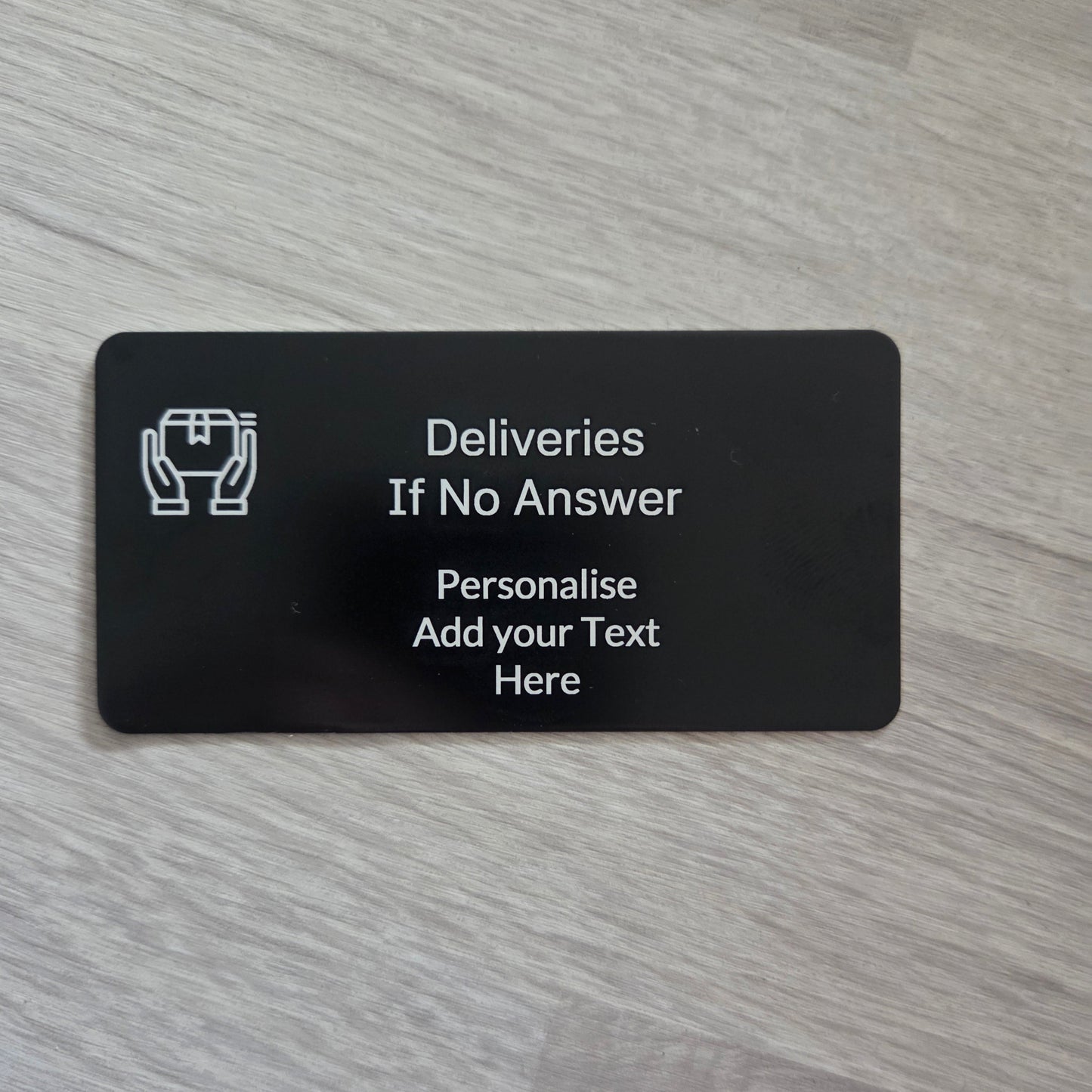 Black card with text and a logo on a wooden surface