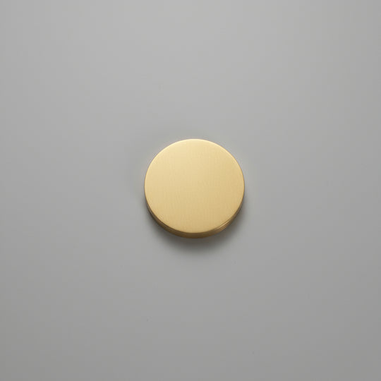 Gold circular object on a gray wooden surface