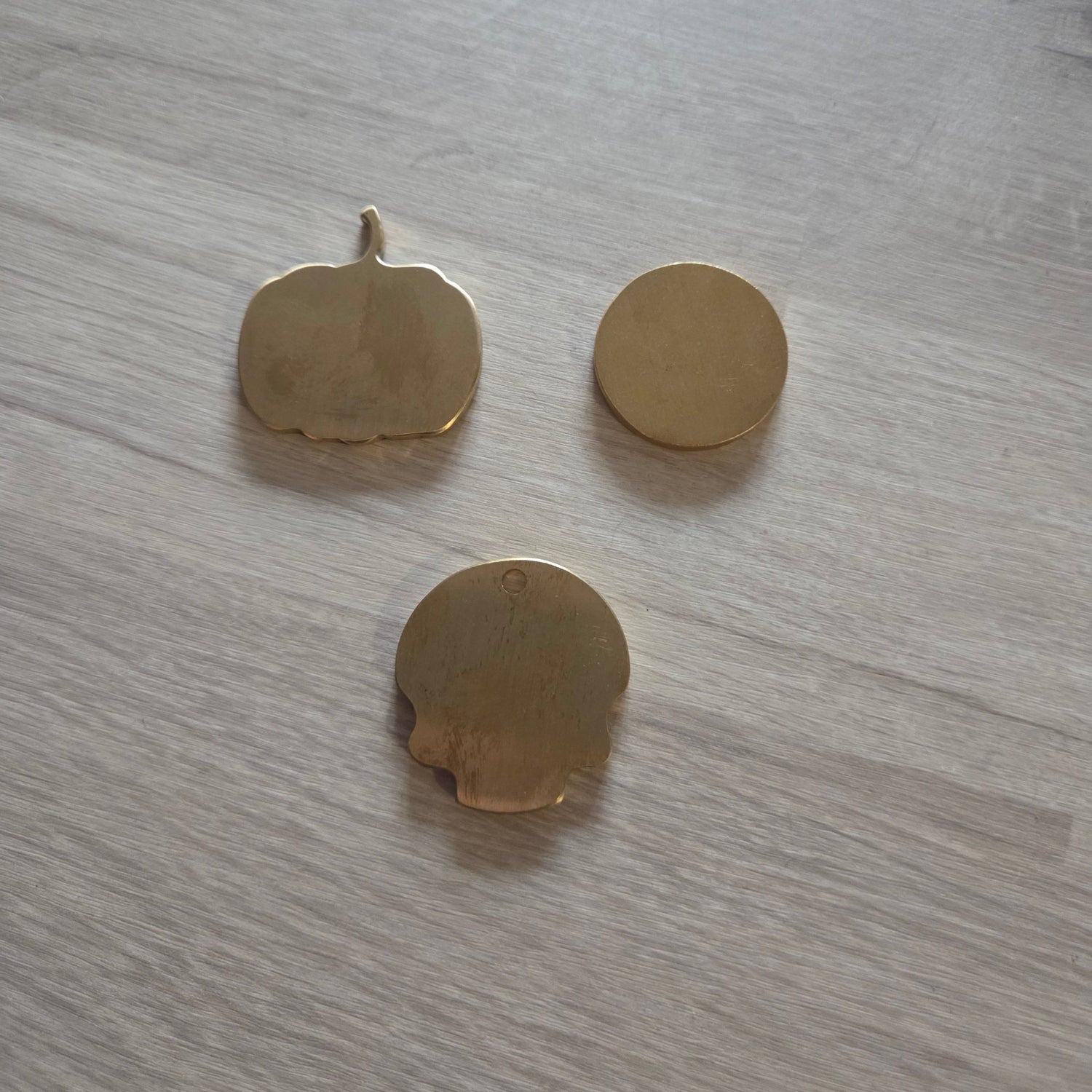 Three gold shapes objects on a wooden surface