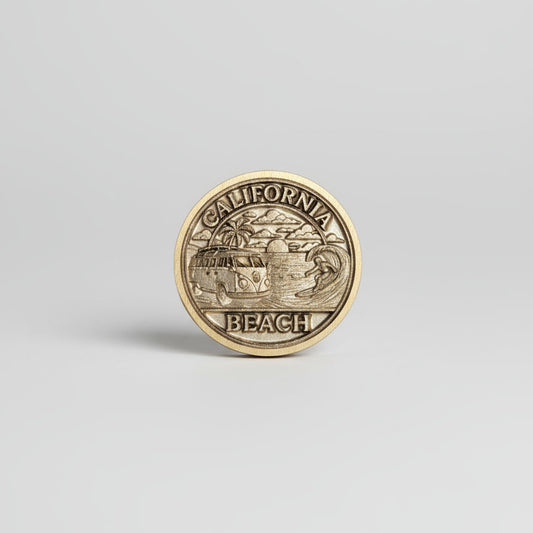 Gold coin with 'California Beach' text on a textured gray surface