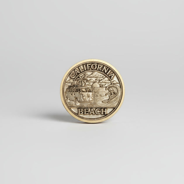 Gold coin with 'California Beach' text on a textured gray surface