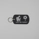 Black keychain with 'Lest We Forget' design on a gray textured background
