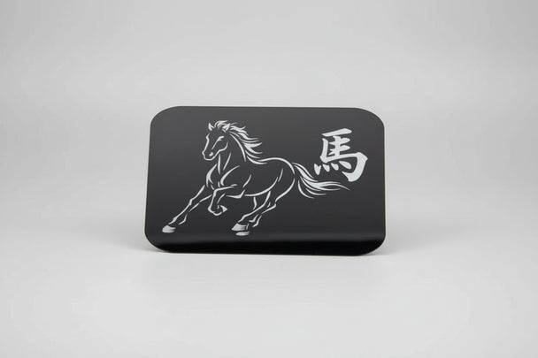 Black card with white horse design and text held against a textured gray background
