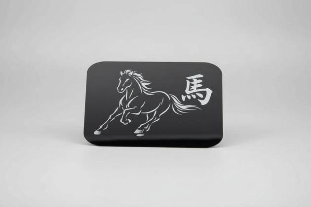 Black card with white horse design and text held against a textured gray background